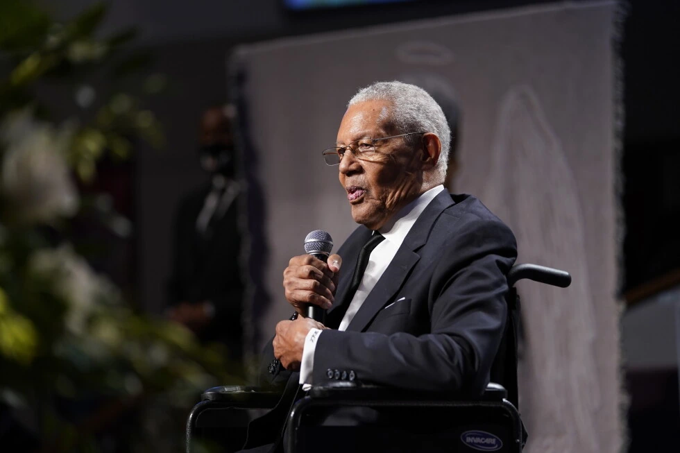 Pastor Charles Lawson speaking into a microphone on stage